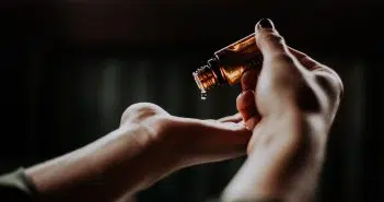 person holding amber glass bottle
